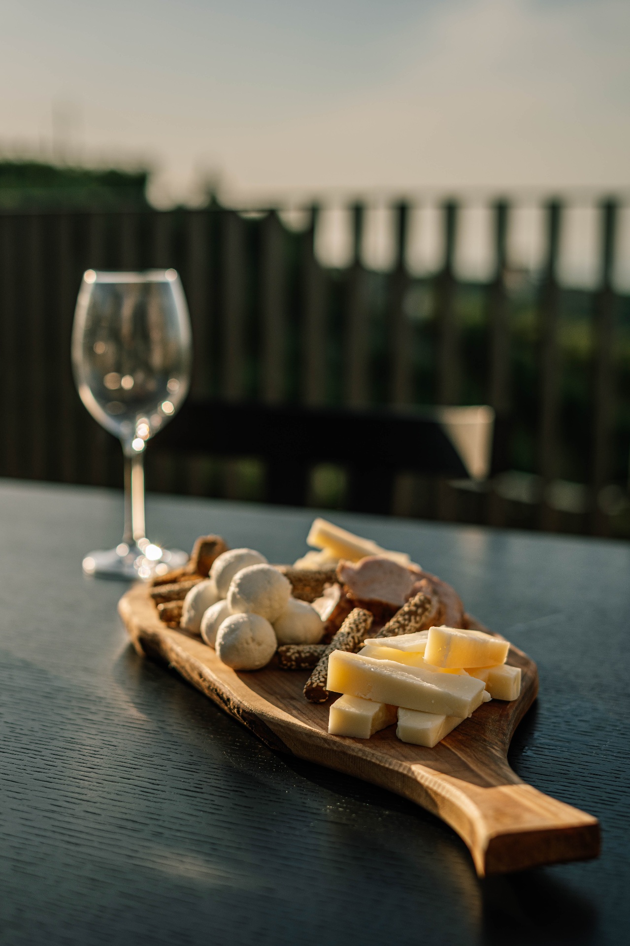 Wine glass and Cretan cheese board on a private villa terrace at sunset